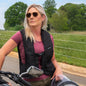 Woman wearing a Hit-Air ultra reflective life vest sitting on a motorcycle.