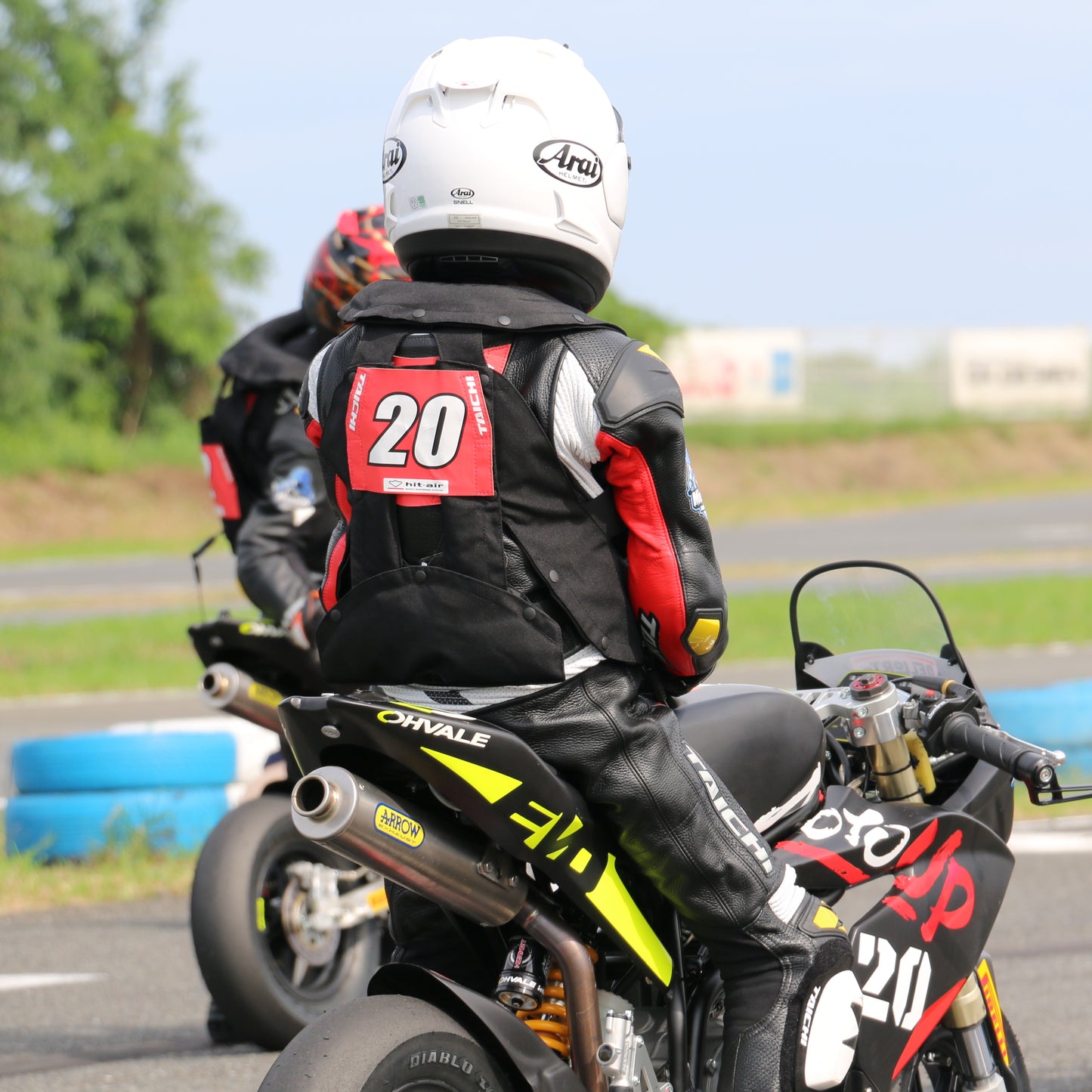 Motorcycle rider (child) in SKV airbag vest for enhanced safety at the track.