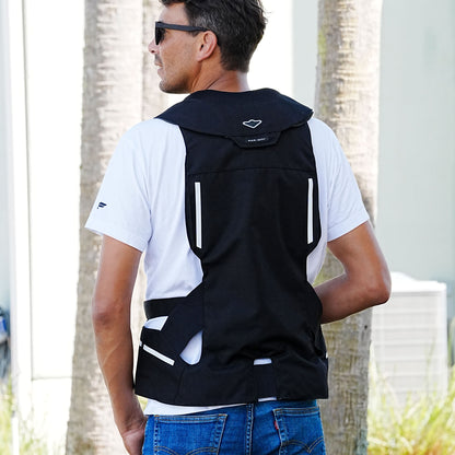 Back of a man wearing a Hit-Air motorcycle safety vest  with a blurred outdoor background.