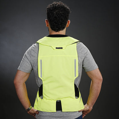 Person wearing a bright yellow ST Hit Air safety vest on a dark background